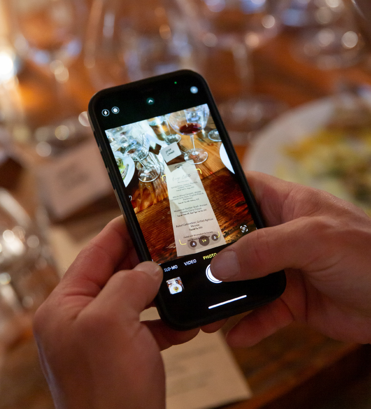 A guest taking a mobile phone picture of the menu at The Kitchen at Middleground Farms